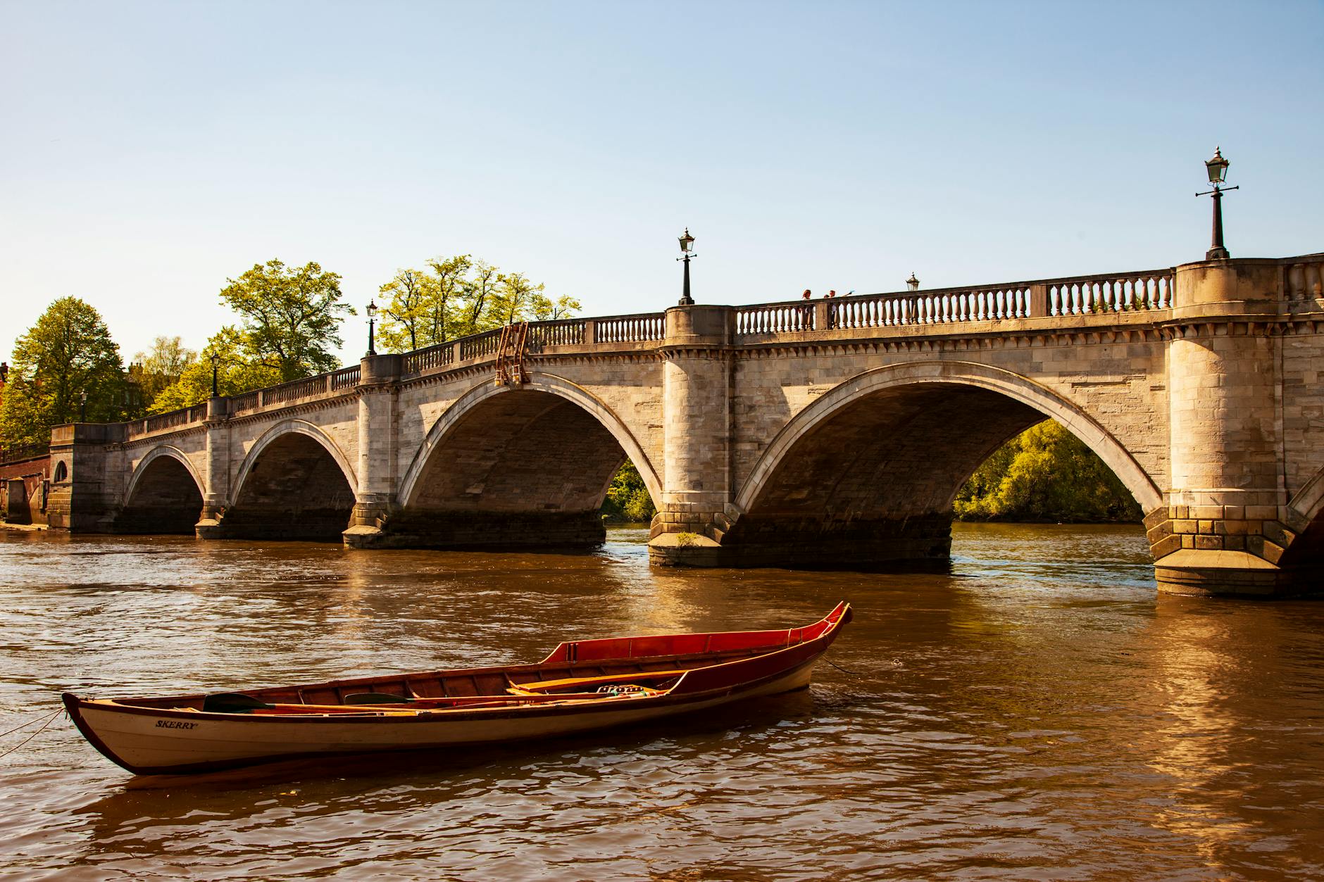 view of empty boat and old arch bridge